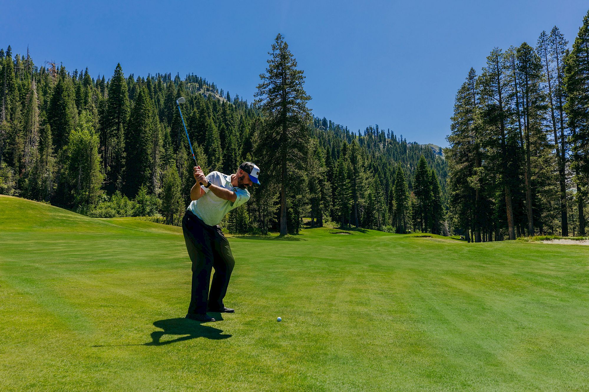 Golf at Everline with forested Olympic Valley mountains